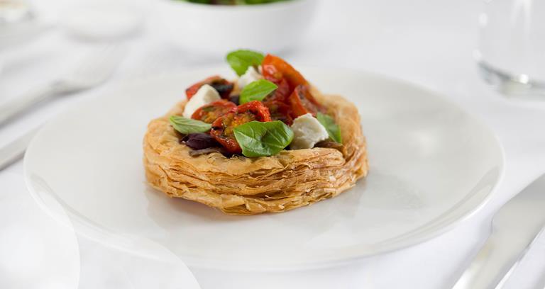 Caramelised onion tart with anchovy, roasted cherry tomatoes, goat's feta and basil