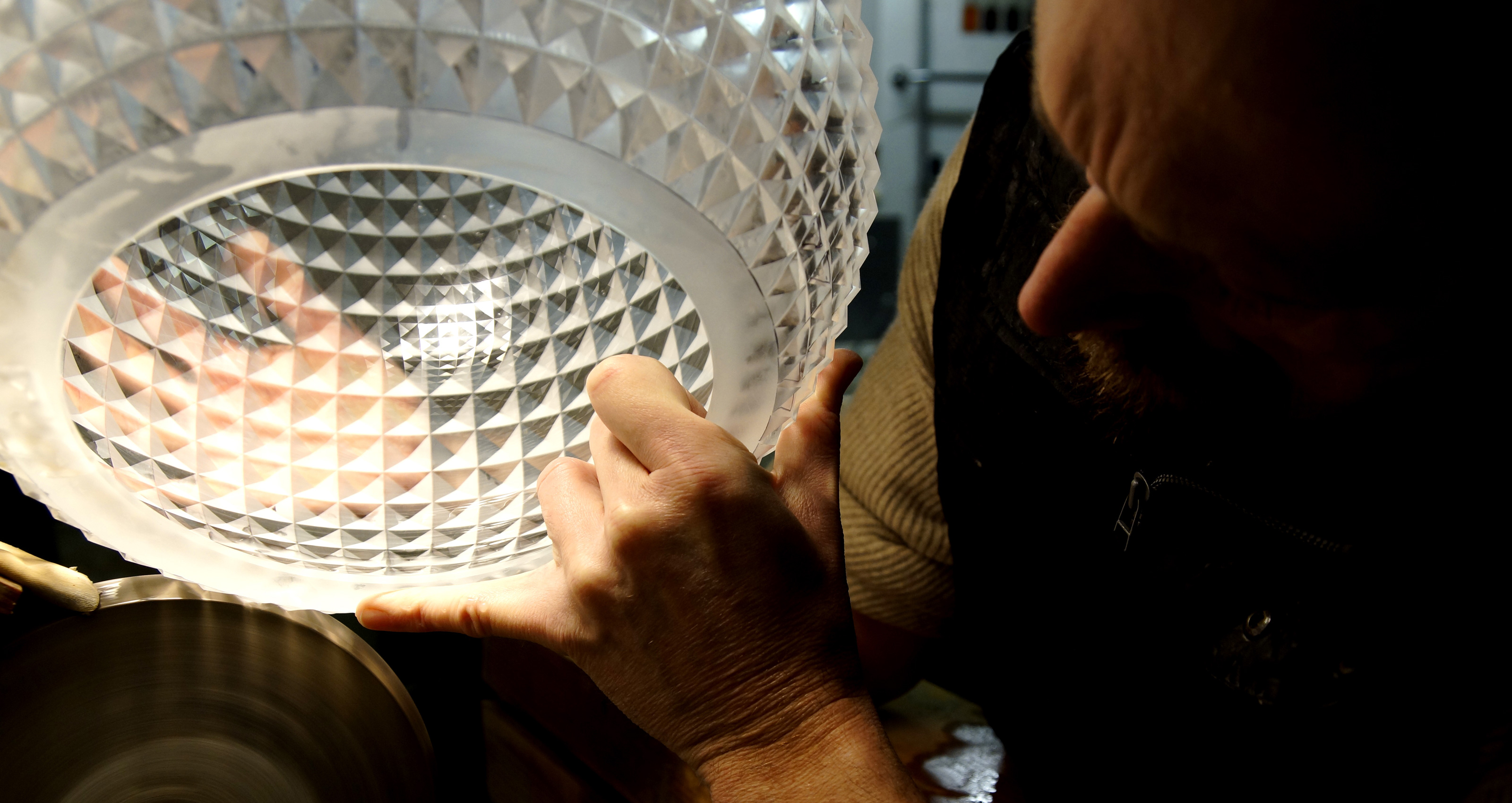 Finishing a piece, Eduard Deubzer grinds the glass on a stone wheel